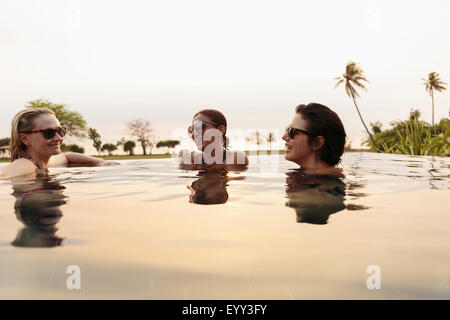 Lächelnde Frauen entspannen im Infinity-pool Stockfoto