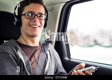 Kaukasischen Mann anhören von MP3-Player im Auto Stockfoto