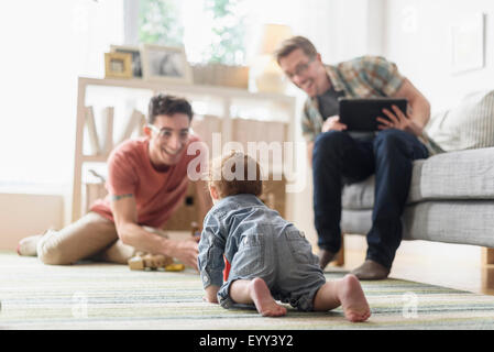 Kaukasische Schwule Väter und Baby im Wohnzimmer entspannen Stockfoto