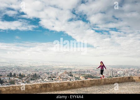 Kaukasische Frau an Wand Blick auf malerische Stadtbild, Granada, Spanien Stockfoto