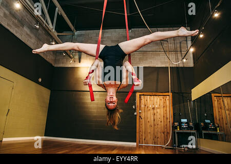 Kaukasische Acrobat hängen von Seilen im studio Stockfoto