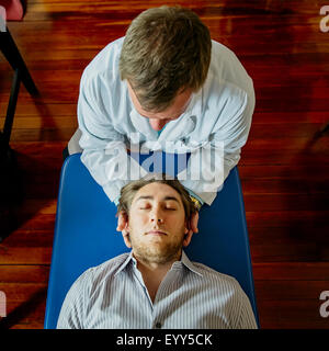 Kaukasische Arzt Hals des Patienten anpassen Stockfoto