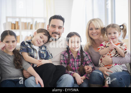 Kaukasische Eltern und Kinder Lächeln im Wohnzimmer Stockfoto