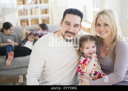 Kaukasische Eltern und Tochter lächelnd in Wohnzimmer Stockfoto