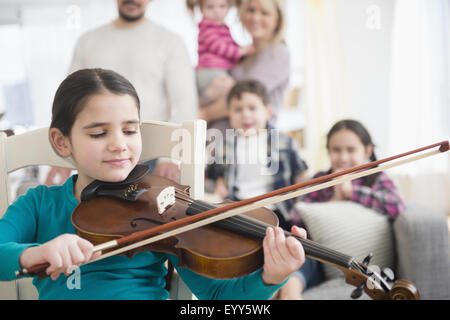 Kaukasische Mädchen spielen Violine im Wohnzimmer Stockfoto