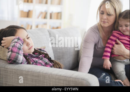 Kaukasische Mutter tröstet aufgeregt Tochter auf sofa Stockfoto