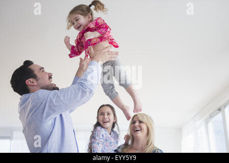 Kaukasische Vater wirft Tochter in Luft Stockfoto
