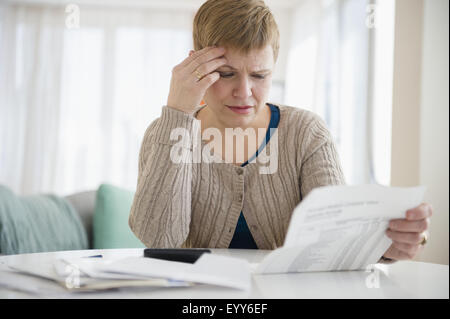 Ängstlich kaukasischen Frau bezahlen Ihrer Rechnungen Stockfoto