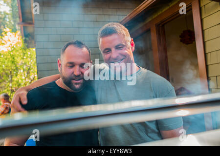 Gay paar Grillen von Lebensmitteln im Hinterhof Stockfoto