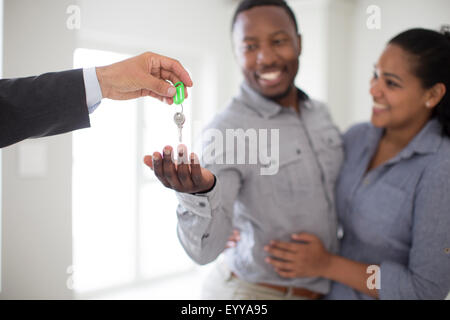 Grundstücksmakler, die paar Schlüssel in neues Zuhause Stockfoto