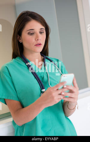 Hispanische Arzt mit Handy im Krankenhaus Stockfoto