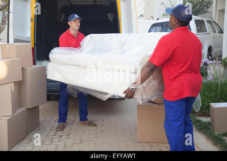 Mover mit Sofa in neues Zuhause Stockfoto