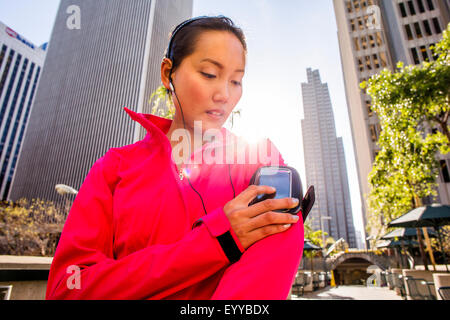 Läufer mit Handy in Stadt Stockfoto