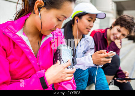 Läufer mit Handys und Ohrhörer auf Stadt Bürgersteig Stockfoto