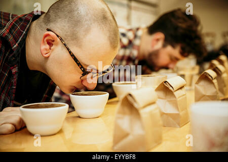 Kaukasische Baristas duftenden Kaffee in Tassen Stockfoto