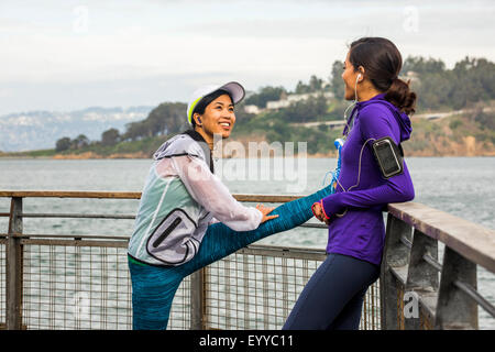Läufer, die Dehnung im waterfront Stockfoto
