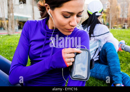 Läufer mit Handy im Stadtpark Stockfoto