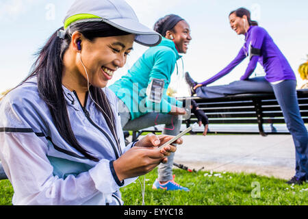 Läufer mit Handy im Stadtpark Stockfoto
