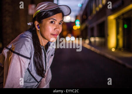 Asiatische Läufer ruht auf Stadtstraße in der Nacht Stockfoto