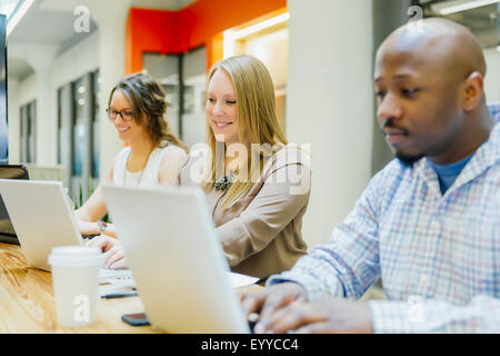 Geschäftsleute auf Laptops im Büro treffen Stockfoto