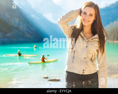 Kaukasische Mädchen stehen am Lake Louise, Banff, Alberta, Kanada Stockfoto