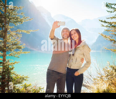 Kaukasische paar unter Handy Selfie am Lake Louise, Banff, Alberta, Kanada Stockfoto