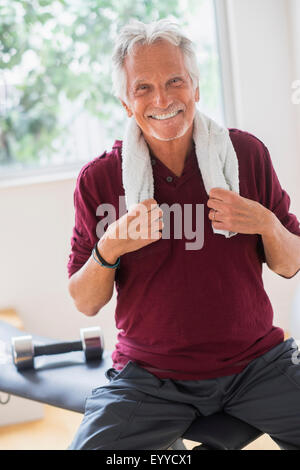 Lächelnder älterer kaukasischen Mann ruht im Fitness-Studio Stockfoto