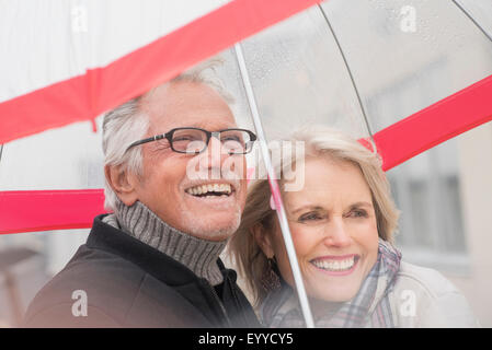 Ältere kaukasischen paar stehen unter Dach Stockfoto