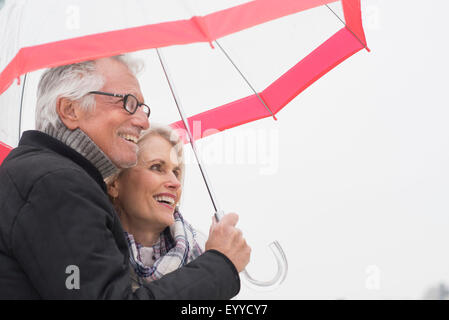 Ältere kaukasischen paar stehen unter Dach Stockfoto