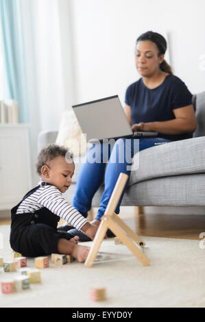 Gemischte Rennen Mutter und Baby Sohn im Wohnzimmer entspannen Stockfoto