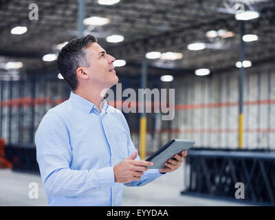 Kaukasische Geschäftsmann mit digital-Tablette in leere Lager Stockfoto