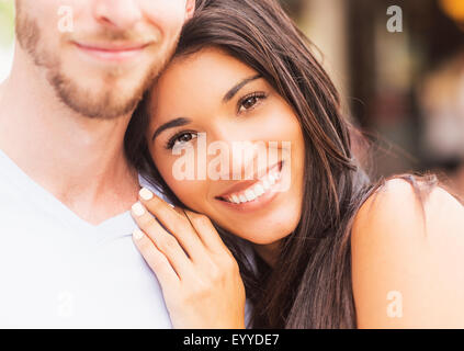 Hispanic Frau umarmt Freund auf Bürgersteig Stockfoto