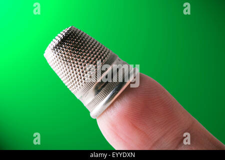 silbrig Fingerhut auf einen finger Stockfoto