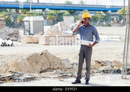 Architekt im harten Hut reden über Handy schwarz Stockfoto