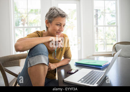 Frau mit Laptop im Wohnzimmer Stockfoto