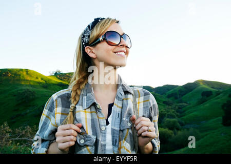 Kaukasische Frau lächelnd auf ländlichen Hügel Stockfoto