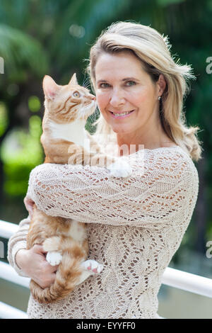 Lächelnd kaukasischen Frau Holding Katze im freien Stockfoto