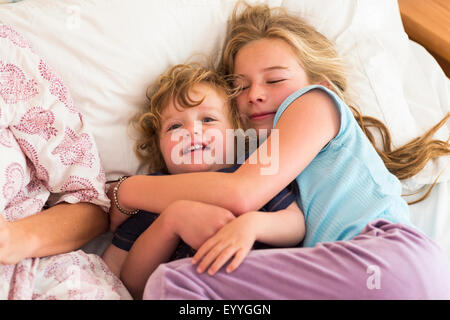 Kaukasische Bruder und Schwester kuscheln im Bett Stockfoto