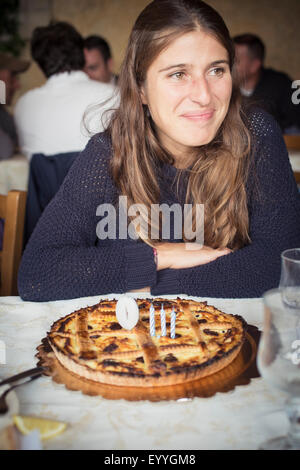 Kaukasische Frau mit Geburtstagstorte im restaurant Stockfoto