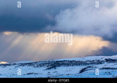 die Sonne bricht durch die Wolken über den verschneiten Fjell, Tromsø, Norwegen, Troms Stockfoto