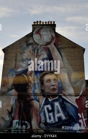 Großes Wandgemälde an der Seite einer Terrasse des Hauses in Glasgow, das Netball-Spieler anlässlich der Commonwealth-Spiele 2014 in Schottland zeigt Stockfoto