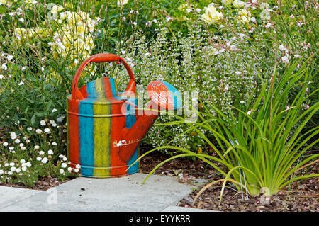 bunte Gießkanne in einem Garten, Deutschland Stockfoto