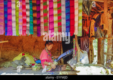 Frau des Stammes Palong mit traditioneller Kleidung arbeitet mit einem Webstuhl, Thailand, Chiang Rai Stockfoto