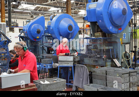 Arbeiter in einer Fabrik zur Herstellung von Metallteilen für die Bauindustrie mit großen Stahl-Pressmaschinen