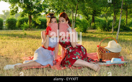 zwei Spion Mädchen verstecken Gesicht hinter dem Buch Pin-up- Stockfoto