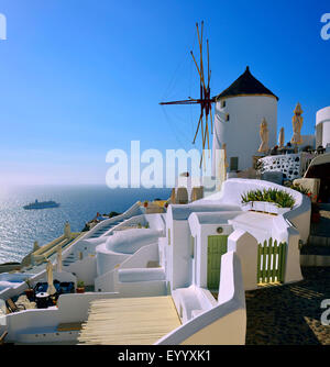 Luxuriöse Hotels und Windmühle im Dorf von Oia, Griechenland, Kykladen, Santorin Stockfoto