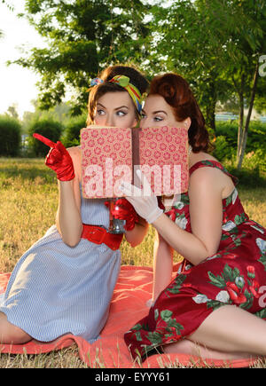 zwei Spion Mädchen verstecken Gesicht hinter der Buch-retro Stockfoto