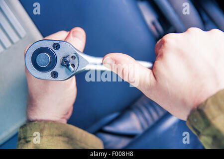 Hände ringend mit Steckschlüssel Stockfoto
