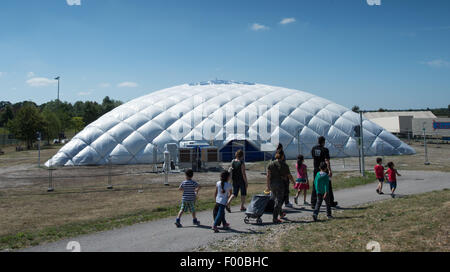 Taufkirchen, Deutschland. 5. August 2015. Eine Familie geht auf den Eingang zu einer Traglufthalle derzeit tätig als Flüchtling Unterkunft in Taufkirchen, Deutschland, 5. August 2015. Foto: PETER KNEFFEL/Dpa/Alamy Live News Stockfoto