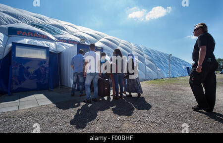 Taufkirchen, Deutschland. 5. August 2015. Eine Familie geht auf den Eingang zu einer Traglufthalle derzeit tätig als Flüchtling Unterkunft in Taufkirchen, Deutschland, 5. August 2015. Foto: PETER KNEFFEL/Dpa/Alamy Live News Stockfoto